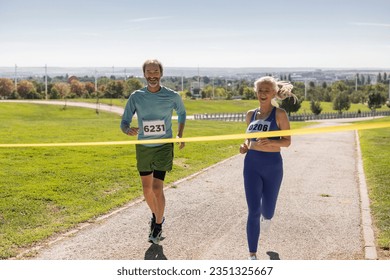 senior people running marathon with bibs reaching the finish line - Powered by Shutterstock