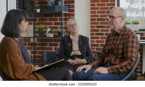 Senior Person Having Discussion With Woman About Alcohol Addiction At Aa Meeting. Man Sharing Story About Progress And Recovery With People In Circle At Rehabilitation Program.