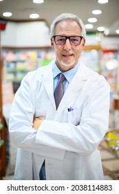 Senior Pharmacist Smiling And Folding Arms In His Store