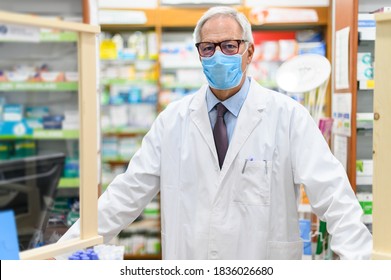 Senior pharmacist wearing a protective mask in his store, coronavirus concept