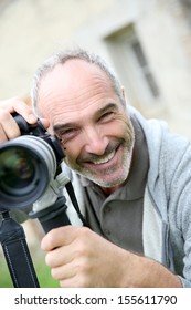 Senior Photographer Using Digital Camera