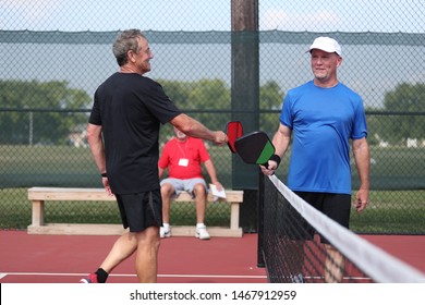 Senior Pickleball Players Congratulate Each Other At The Conclusion Of A Tournament Match.