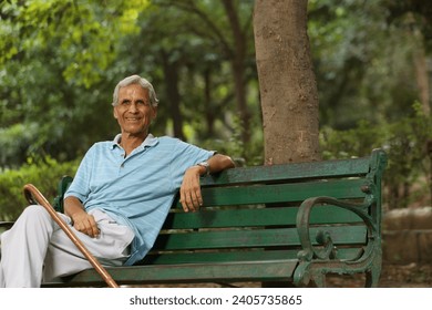 Senior Portraits. cheerful senior man sitting on bench with walking stick at park - Powered by Shutterstock