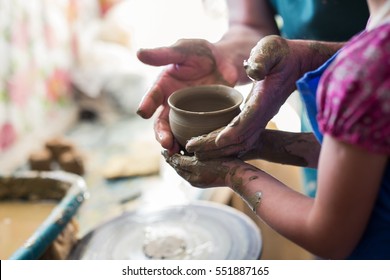 Senior Potter Teaching A Little Girl The Art Of Pottery. Child Working With Clay, Creating Ceramic Pot On Sculpting Wheel. Concept Of Mentorship, Generations. Arts Lessons, Pottery Workshop For Kids