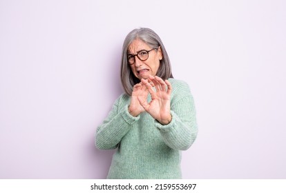 Senior Pretty Woman Feeling Disgusted And Nauseous, Backing Away From Something Nasty, Smelly Or Stinky, Saying Yuck