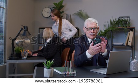 Senior professional businessman grandfather company director in modern office interior using mobile phone texing message working watching video successful people communicating. Elderly freelancer man [[stock_photo]] © 