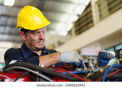 Senior professional electrical or industrial engineer inspecting and repairing a robotic system in the manufacturing factory close up. Robotic technician repairing - fixing a automated machine. - Powered by Shutterstock