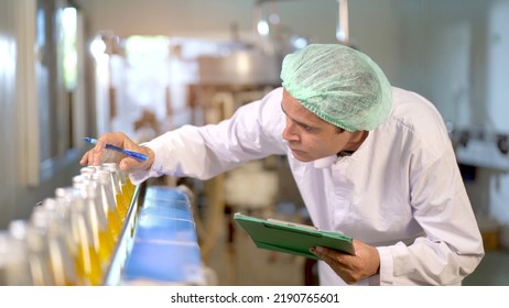 Senior professional quality control officer inspecting the manufacturing line and computer system in the beverage bottling factory. Industrial or machinery engineer inspecting and fixing the machines. - Powered by Shutterstock