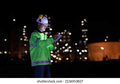 Senior Project Engineer Wearing Safety Jacket And PPE Work At Night, Outdoor Working At Industrial Site, A Man Working At Night Inside Oil And Gas Refinery Plant Industry Factory