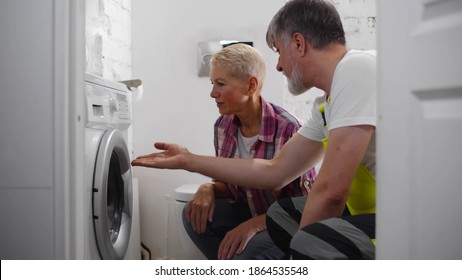 Senior Repairman Fixing Washing Machine For Woman Client. Aged Maintenance Worker Installing New Clothes Drying For Customer. Smiling Handyman Repairing Broken Washing Machine