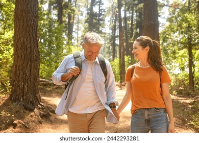 Senior Retired Couple Holding Hands Hiking Along Trail In Countryside - Powered by Shutterstock