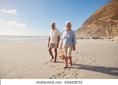 Senior Retired Couple Walking Along Beach Hand In Hand Together - Powered by Shutterstock