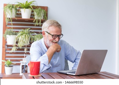 Senior Retirement Man Is Enjoy Chating With Someone Using His Laptop At Home And Feeling Happy