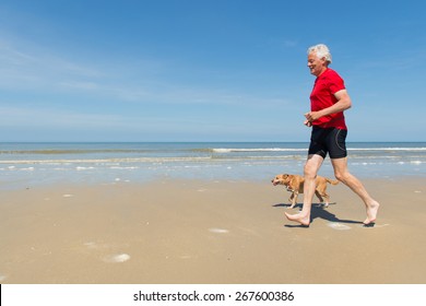 Senior runner with dog at the beach