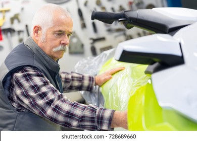 Senior Seller Inspecting Jetski In His Store