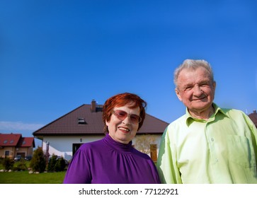 Senior Smiling Couple In Front Of Their New House