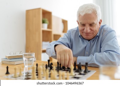 Senior Smiling Man Enjoying Playing Chess