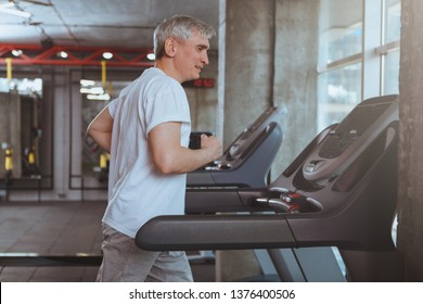 Senior Sportsman Running On A Treadmill At The Gym, Copy Space. Healthy Elderly Man Enjoying Working Out At Sport Studio, Jogging On A Running Machine. Cardio, Endurance, Health Concept