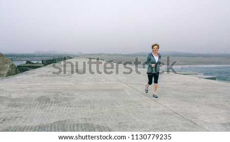 Senior sportswoman with headphones running