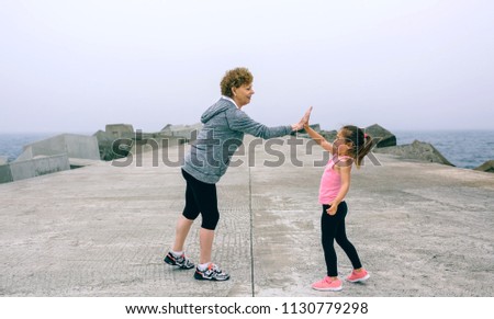 Foto Bild Seniorsportlerin und kleines Mädchen High Five