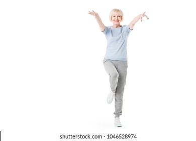 Senior Sportswoman Standing On One Leg Isolated On White