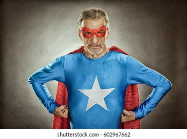 Senior Superhero Man In Blue Costume Red Cloak And Mask Old Portrait On Textured Background