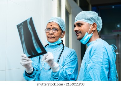 senior surgeon with practitioner discussing from xray report at hospital corridor - concept of communication, assistance and healthcare or medical service - Powered by Shutterstock