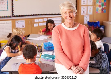 Senior teacher in classroom with elementary school kids - Shutterstock ID 388655215