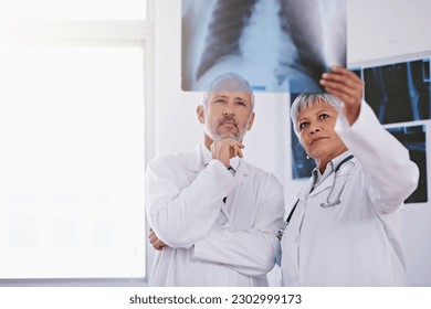 Senior team of doctors, review xray for surgery and people in radiology, cardiovascular health at clinic. Lung scan, old man thinking about diagnosis and woman surgeon collaboration with assessment - Powered by Shutterstock