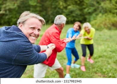Senior team at tug of war as teambuilding exercise at a workshop - Shutterstock ID 1517981945