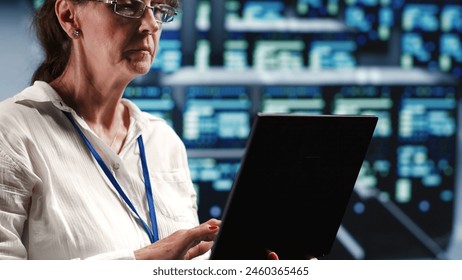 Senior technician in server room equipped to handle modern computing requirements, doing regular upgrades to components, increasing processing power and storage capacity to prevent flaws - Powered by Shutterstock