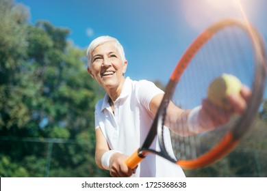 Senior Tennis – Pretty Mature Woman Serving Ball in Tennis - Powered by Shutterstock