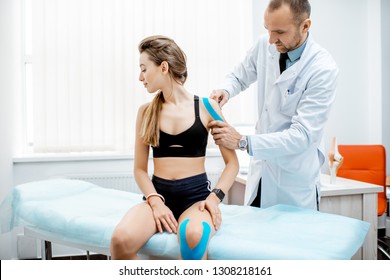 Senior therapist applying kinesio tape on a woman's shoulder during the medical treatment in the office - Powered by Shutterstock