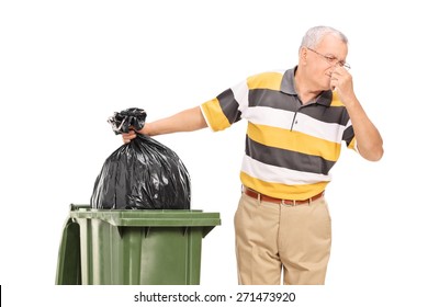 Senior throwing away a stinky bag of trash isolated on white background