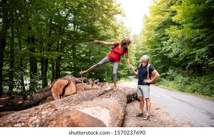 Senior Tourist Couple With Backpacks Walking In Forest In Nature.