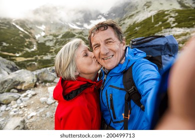 Senior tourist couple hiking and taking selfie at the beautiful mountains - Powered by Shutterstock