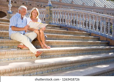 Senior Tourist Couple On City Break Vacation On Steps With Map