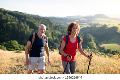 Senior tourist couple travellers hiking in nature, walking and talking. - Powered by Shutterstock