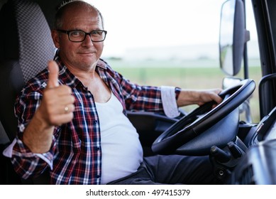 Senior Truck Driver Showing Thumbs Up While Driving.