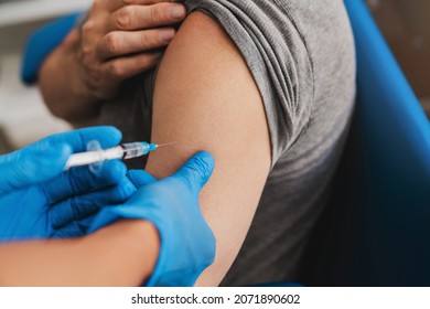 Senior Vaccination Concept. Doctor Giving An Injection To Older Elderly People Patient In Clinic. Coronavirus Covid 19 Vaccine. Doctor Making An Injection With A Syringe