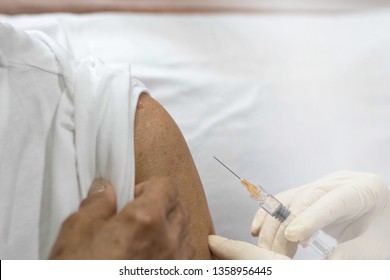 Senior Vaccination Concept. Elderly Getting Immune Vaccine At Arm For Flu Shot, Pneumonia, And Shingles(MMR) In Hospital By Nurse. Doctor Giving An Injection To Older People Patient In Clinic.