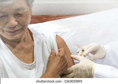 Senior Vaccination Concept. Elderly Getting Immune Vaccine At Arm For Flu Shot, Pneumonia, And Shingles(MMR) In Hospital By Nurse. Doctor Giving An Injection To Older People Patient In Clinic.