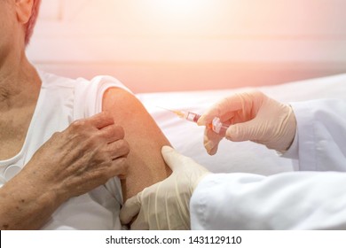 Senior Vaccination Concept. Elderly Getting Immune Vaccine At Arm For Flu Shot, Pneumonia, And Shingles(MMR) In Hospital By Nurse. Doctor Giving An Injection To Older People Patient In Clinic.