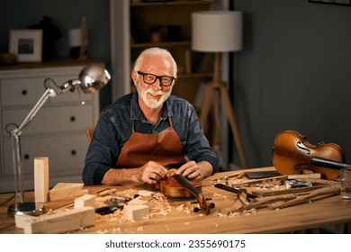 Senior violin maker repairing a violin - Powered by Shutterstock