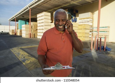 Senior Warehouse Worker Having Conversation On Mobile Phone