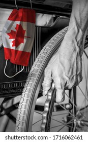 Senior In Wheelchair At Nursing Home In Black And White With Hanging Canadian Flag Face Mask In Color. Concept Of Covid-19 Outbreak In Canadian Nursing Care Homes Or Elderly Retirement Facilities