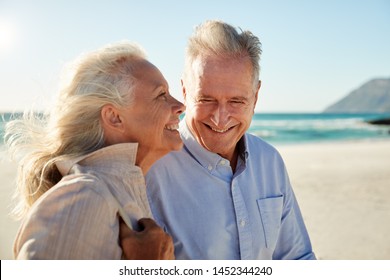 Senior white couple walking on a sunny beach, waist up, side view, close up - Powered by Shutterstock