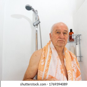 Senior white man after
 the shower. He wears an orange towel over the shoulders. - Powered by Shutterstock