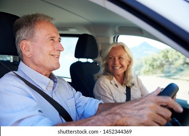 Senior White Man Driving Car, His Wife Beside Him In The Front Passenger Seat, Close Up, Side View