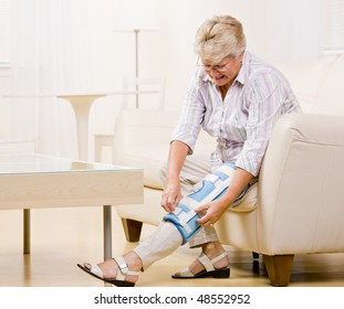 Senior Woman Adjusting Knee Brace